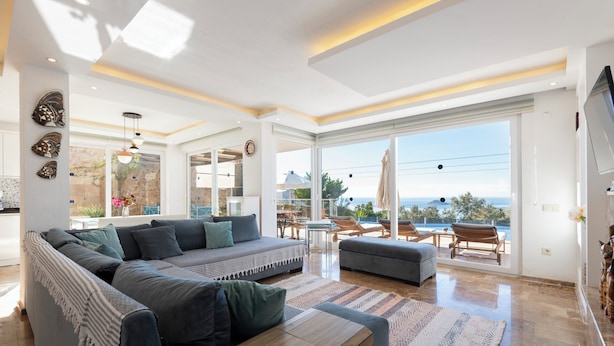A modern living room with a sectional sofa, a coffee table, and a view of the ocean. - Stunning Sea View Villa in Kalkan with Private Pool, 4 Bedrooms, 8 Guests (Antalya)