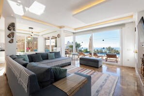 Een moderne woonkamer met een modulaire bank, een salontafel en uitzicht op de oceaan.
