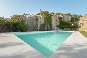 Ein rechteckiger Pool mit klarem Wasser, umgeben von einer Betonplattform.