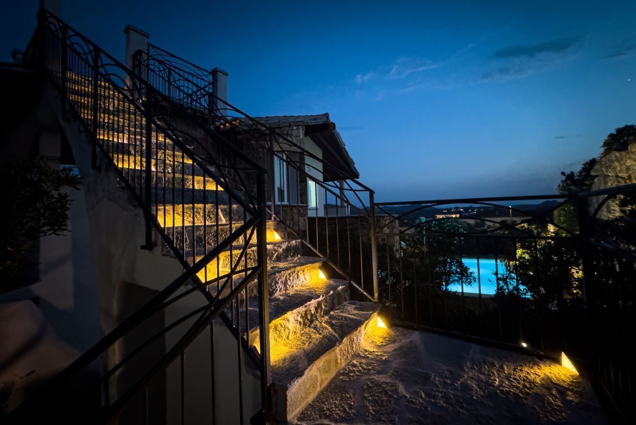 A staircase leading to a balcony with a pool in the background.