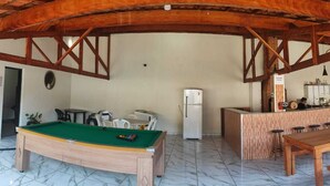 A room with a pool table, a refrigerator, a bar area, and a dining table. - Cozy country house surrounded by nature, with a beautiful sunset view. (Piracicaba)