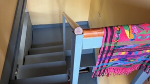 A staircase with a blue handrail and a colorful woven rug at the top. - Charming 1-bedroom apartment in Worcester, private swimming hole. (Worcester)
