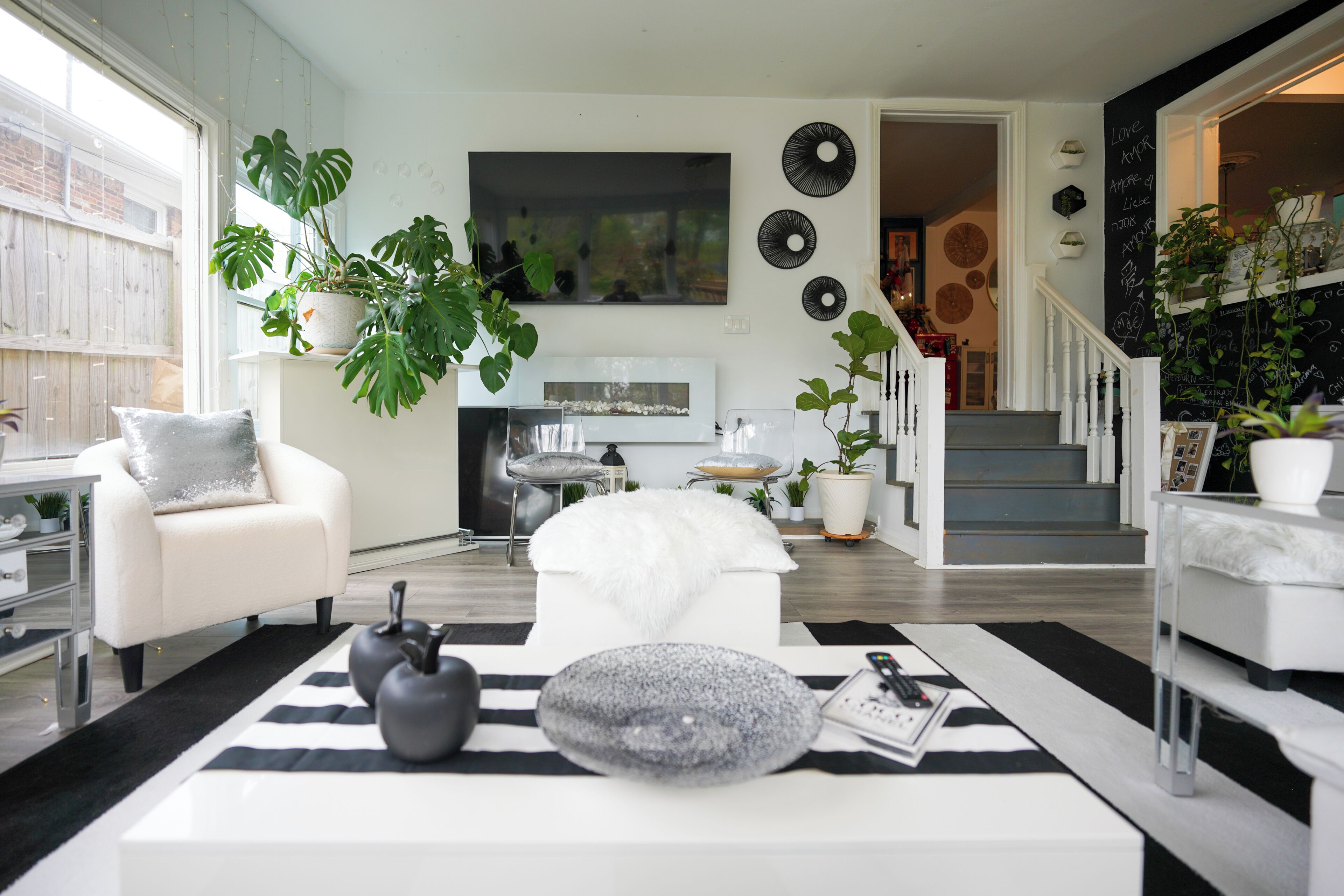 Ein modernes Wohnzimmer mit Sofa, Couchtisch und Dekoration. Eine Treppe führt zu einer weiteren Ebene.