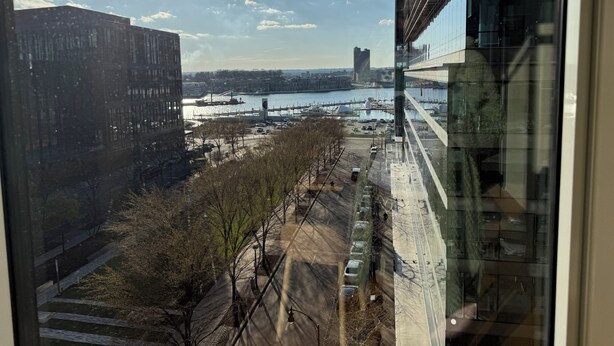 Vista desde un edificio alto con vistas a un río, con arquitectura moderna y cielo despejado.