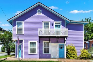 A two-story house with a balcony, a blue door, and a stop sign. - Midnight Magnolia - Historic Victorian Downtown Savannah Stay Near Forsyth Park! (Savannah)