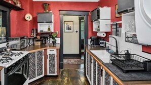 Eine kompakte Küche mit Gasherd, Spüle und Kühlschrank.