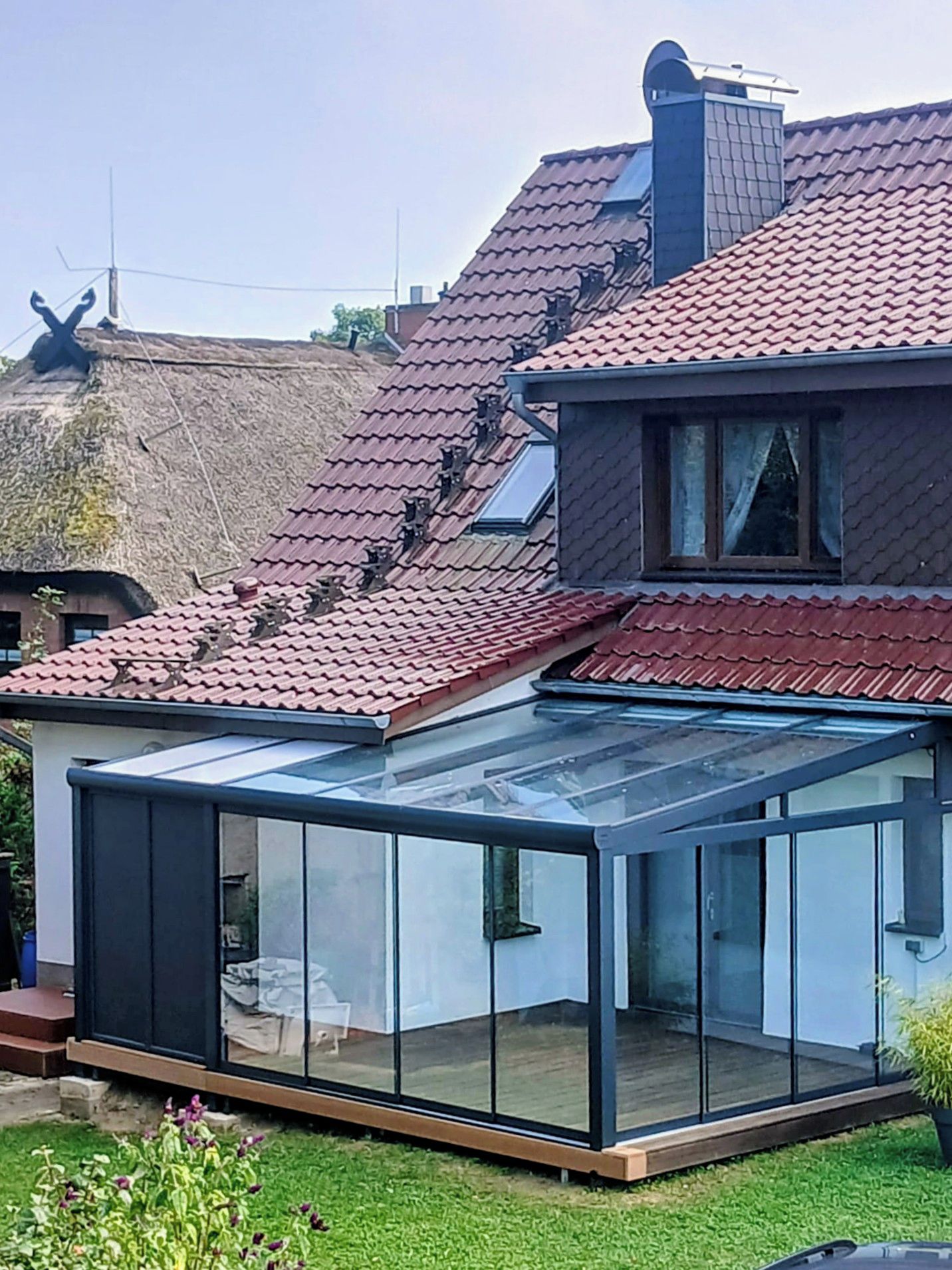 A house with a glass conservatory attached to the main building.