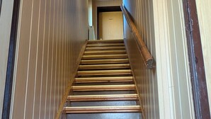 A wooden staircase with a handrail, leading to a door labeled 'PRIVATE.'