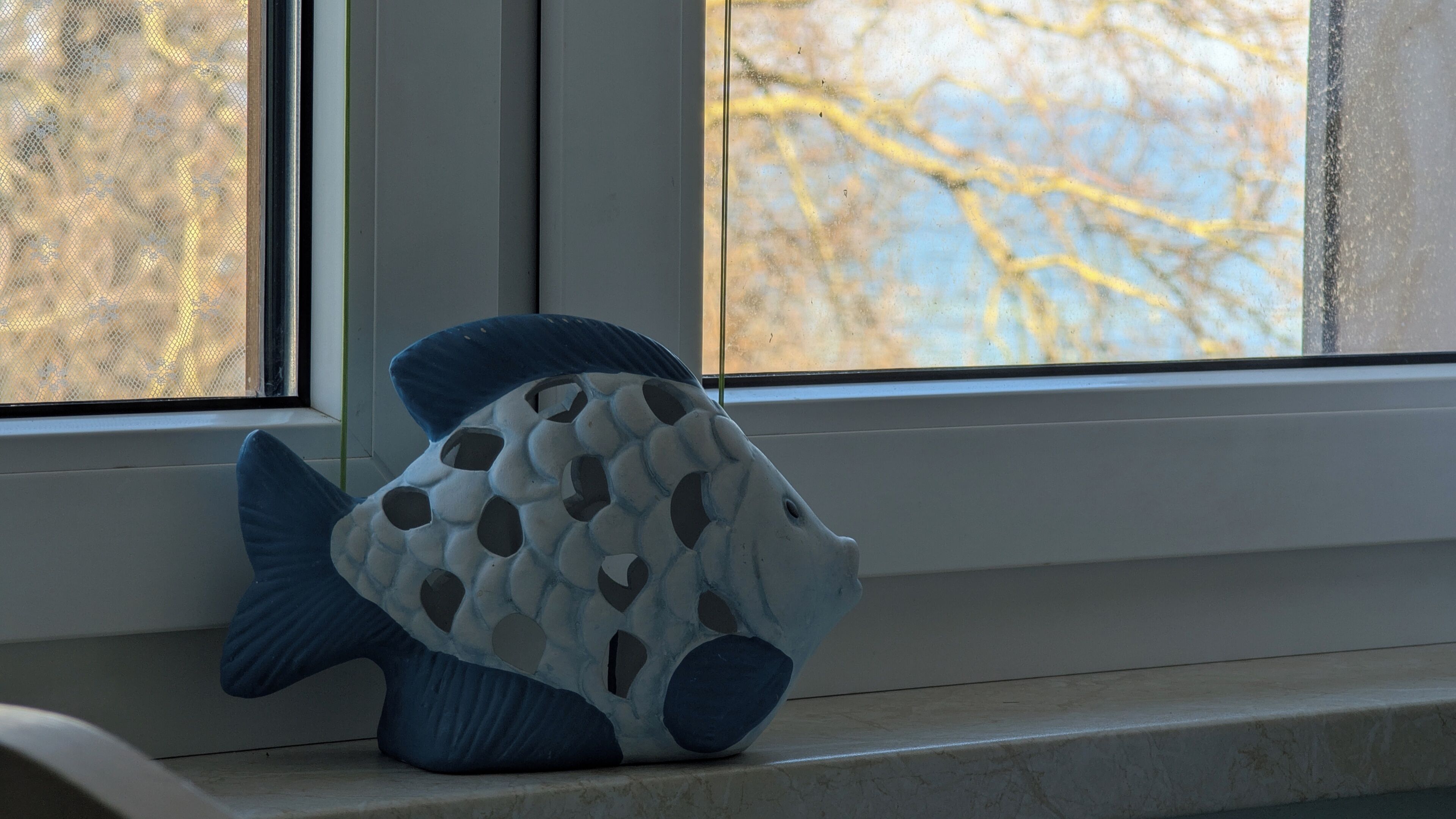 A fish-shaped decorative item on a windowsill.