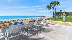 A beachside view with lounge chairs and a clear blue sky. - The perfect tropical sanctuary with turquoise waters and steps from the beach. (Key Colony Beach)