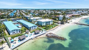 A resort with a beach, pool, and multiple buildings. - The perfect tropical sanctuary with turquoise waters and steps from the beach. (Key Colony Beach)