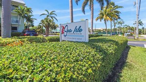 A sign for Sea Isle Condominium with a clear view of the surrounding greenery and palm trees. - The perfect tropical sanctuary with turquoise waters and steps from the beach. (Key Colony Beach)