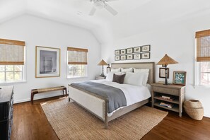 A bedroom with a bed, bedside tables, a bench, and a large window with blinds. - Classic 4-bedroom Home in East Hampton, Minutes from Town (East Hampton)