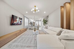 Una sala de estar moderna con un sofá, una mesa de centro y un comedor con sillas y una mesa.