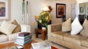 Ein Wohnzimmer mit zwei Sofas, einem Couchtisch und einem roten Teppich.