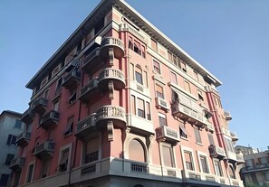 A multi-story building with balconies, arched windows, and a flat roof. - Spacious apartment near sea, airport and downtown Genoa (Genova)