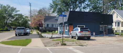 A street view with a blue building, a sign for 'St Clair St,' and parked vehicles.