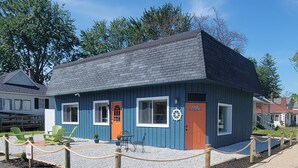A small blue building with a dark roof, a wooden fence, and a rope barrier.