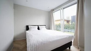 Una camera da letto con un letto grande, una finestra e vista sul verde.
