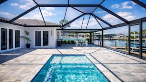 A covered outdoor swimming pool with a view of a marina and buildings.