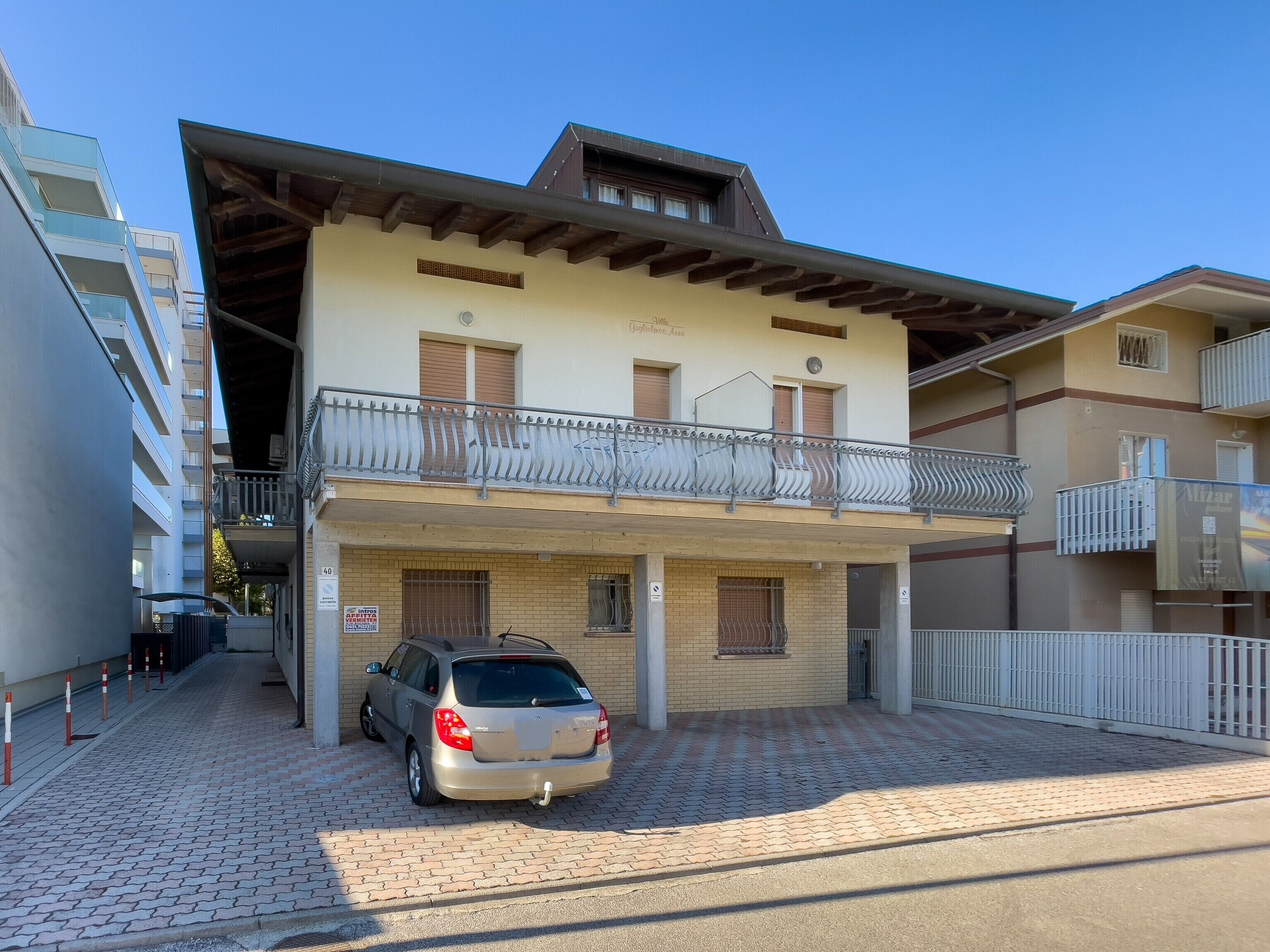 A two-story building with a car parked in front.
