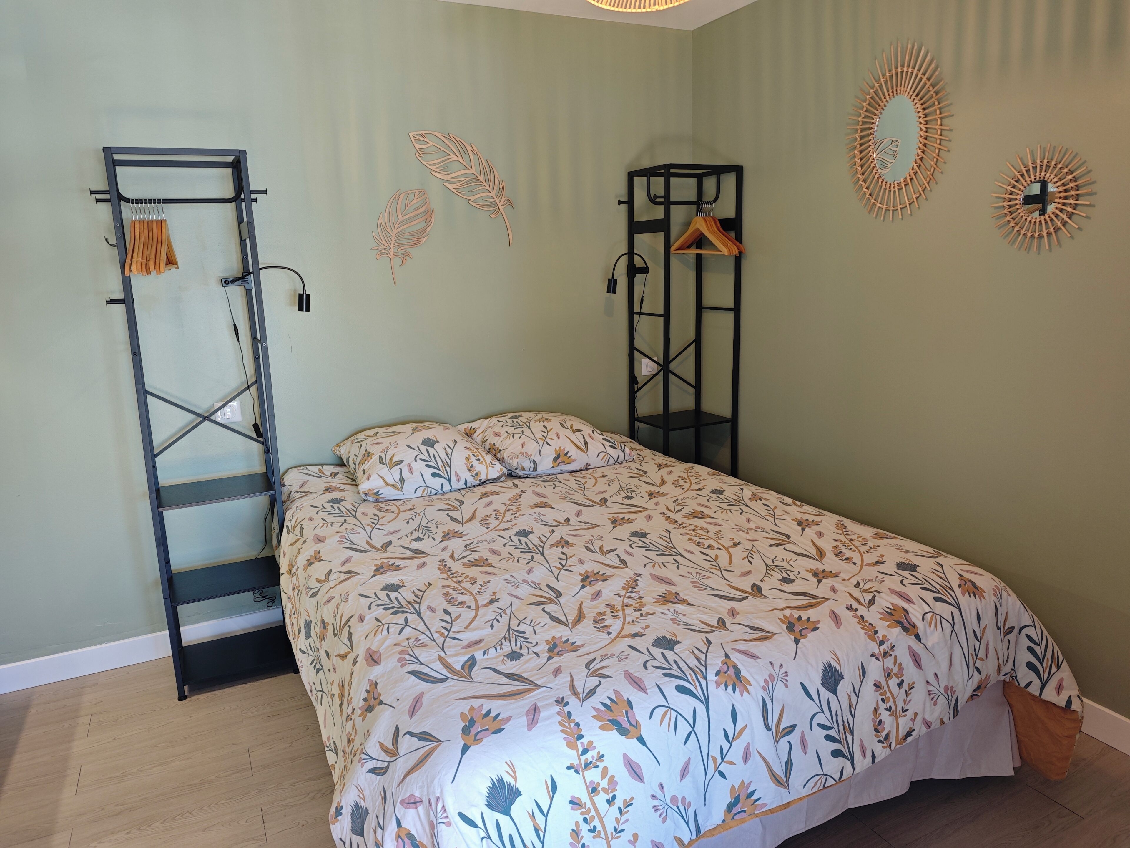 Een slaapkamer met een bed, een kledingkast en decoratie aan de muur.