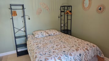 Een slaapkamer met een bed, een kledingkast en decoratie aan de muur.