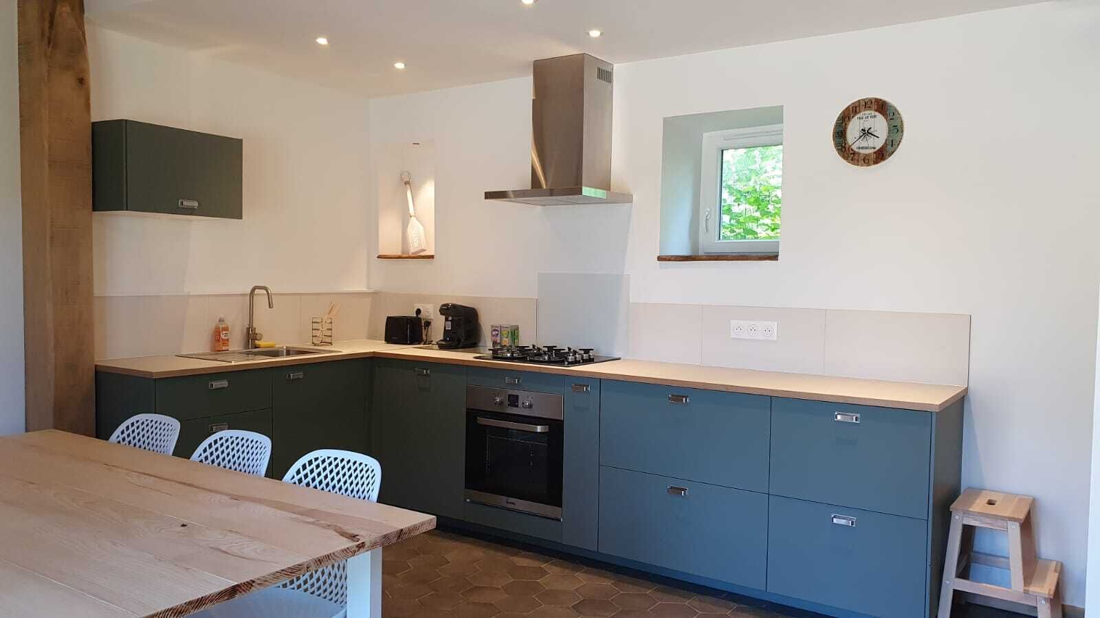 A compact kitchen with a built-in oven, a gas stove, and a window.