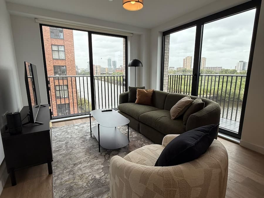 A modern living room with a sofa, armchair, and a small table.