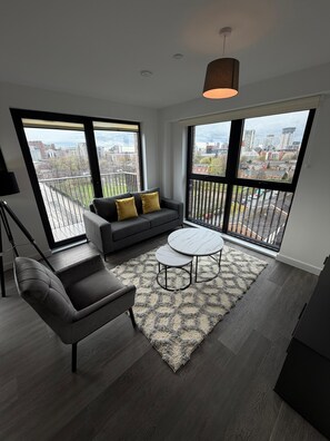 Apartamento Deluxe, balcón, vistas a la ciudad | Zona de estar | Smart TV de 55 pulgadas con canales digitales