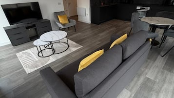 Apartamento Deluxe, balcón, vistas a la ciudad | Zona de estar | Smart TV de 55 pulgadas con canales digitales