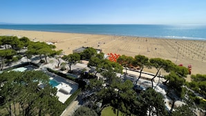 Ein Strandresort mit Schwimmbad, Strand und Blick auf den Ozean.