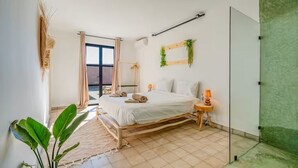 Een slaapkamer met een bed, nachtkastje, lamp en uitzicht op de omgeving.