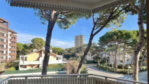 A residential area with a balcony, trees, and buildings. - Lignano Pineta Flat With Balcony (Lignano Sabbiadoro)