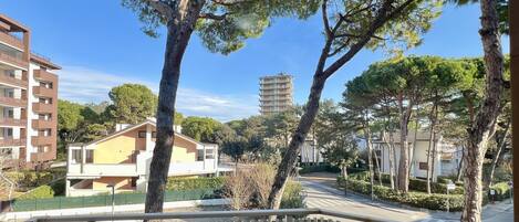 A residential area with a balcony, trees, and buildings.