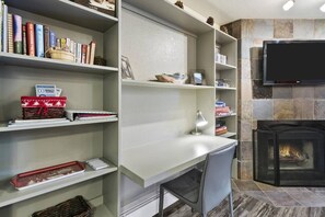 A modern living room with a fireplace, a flat-screen TV mounted on the wall, and a desk with a chair. - Park City Snowcrest Chalet (Park City)