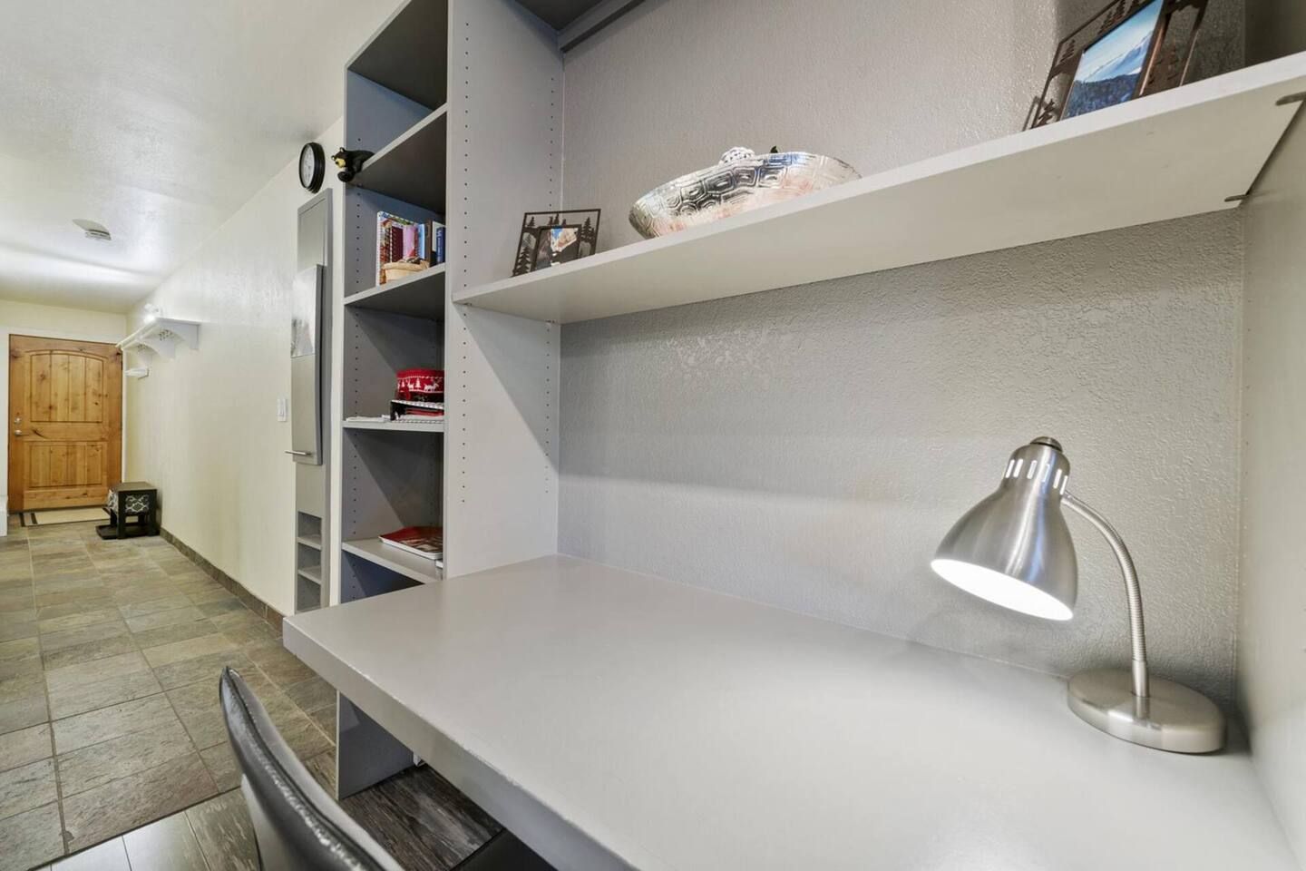 Een moderne keuken met witte kasten, een roestvrijstalen spoelbak en een inbouw afzuigkap.