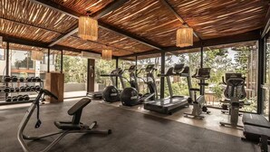A gym with exercise equipment, large windows, and a wooden ceiling. - Siwa Tulum 2BR Luxury Condo with Private Pool + Rooftop (Tulum)