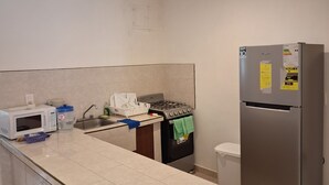 A kitchen with a microwave, stove, sink, and refrigerator. - Cozy house 150 meters from the Beach in Chicxulub Puerto (Chicxulub)