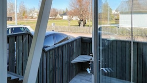 A wooden deck with a metal railing, a clear view of a residential area, and a house in the background. - 6 Person Holiday Home in Timmernabben (Fliseryd)