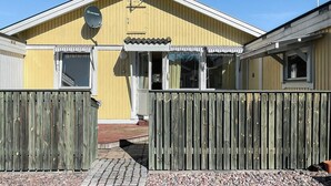 A yellow building with a satellite dish, a gated entrance, and a small porch. - 6 Person Holiday Home in Timmernabben (Fliseryd)