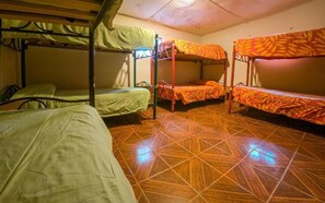 A dormitory room with bunk beds, a tiled floor, and a simple layout. - La Casa del Sol Naciente (San Pedro de Atacama)