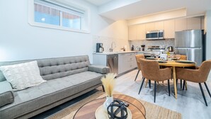Una cocina moderna con comedor, sofá y ventana.