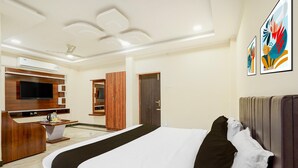 A hotel room with a bed, a TV, a desk, and a wardrobe. - Townhouse Vellore Fort (Vellore)