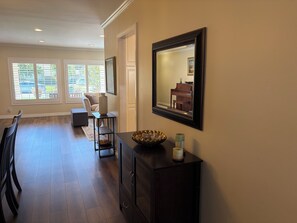 A spacious living room with a dining area, large windows, a piano, and a dark wooden cabinet. - Clean, Bright & Comfortable Pool Home w/separate Poolhouse Studio (Los Angeles)