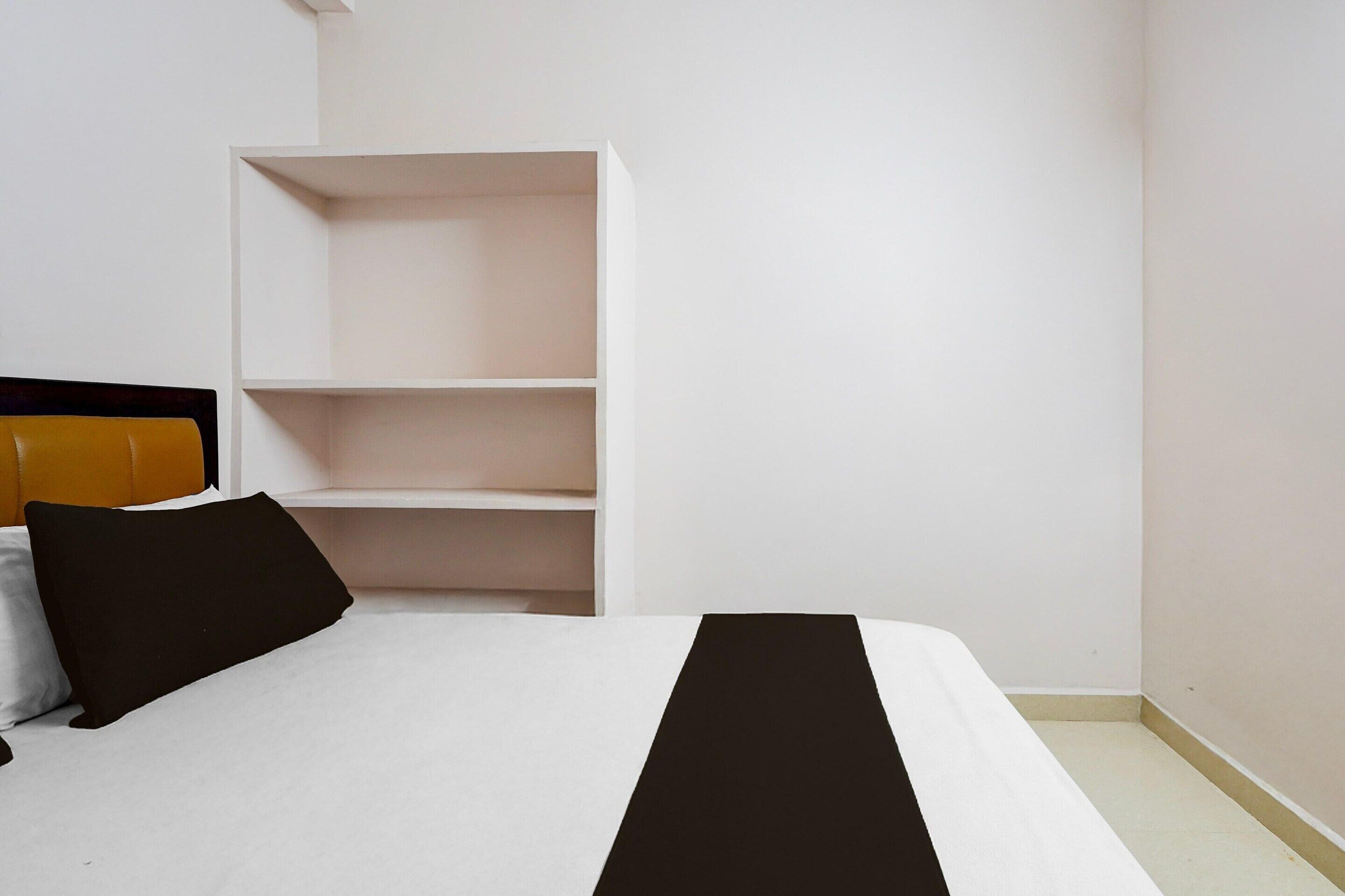 Ein Schlafzimmer mit einem Bett, einem weißen Kleiderschrank und einem Kopfteil.