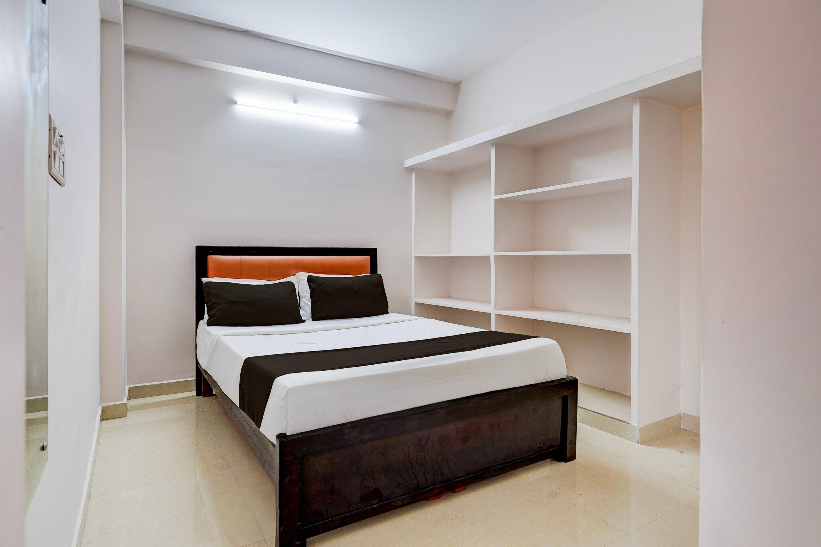 Une chambre à coucher avec un lit, une armoire blanche et une étagère blanche.
