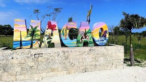 Un letrero con pintura que deletrea 'LAGOON' contra un cielo despejado.