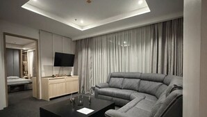 Una sala moderna con un sofá modular, una mesa de centro, un televisor y un mueble empotrado para entretenimiento.
