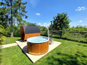 A hot tub and a barrel-shaped sauna in a grassy outdoor area. - Les Écrins de La Ronce • Swimming Pool • Nature • SPA  (Rouvres)